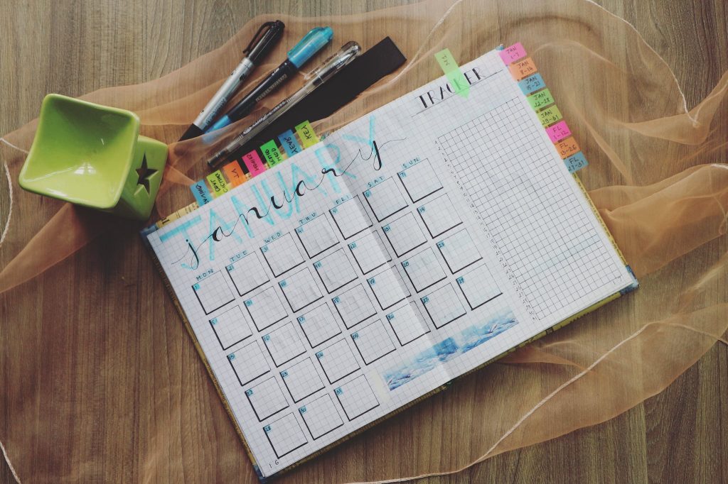 One month calendar with pens on table