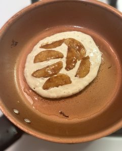Cinnamon Apples on top of a cooking pancake