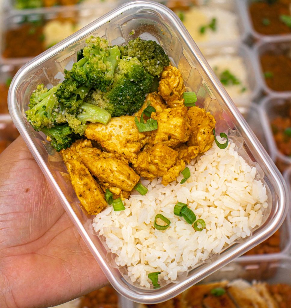 Meal prep featuring chicken, broccoli, and rice in a container, perfect for healthy eating on-the-go.